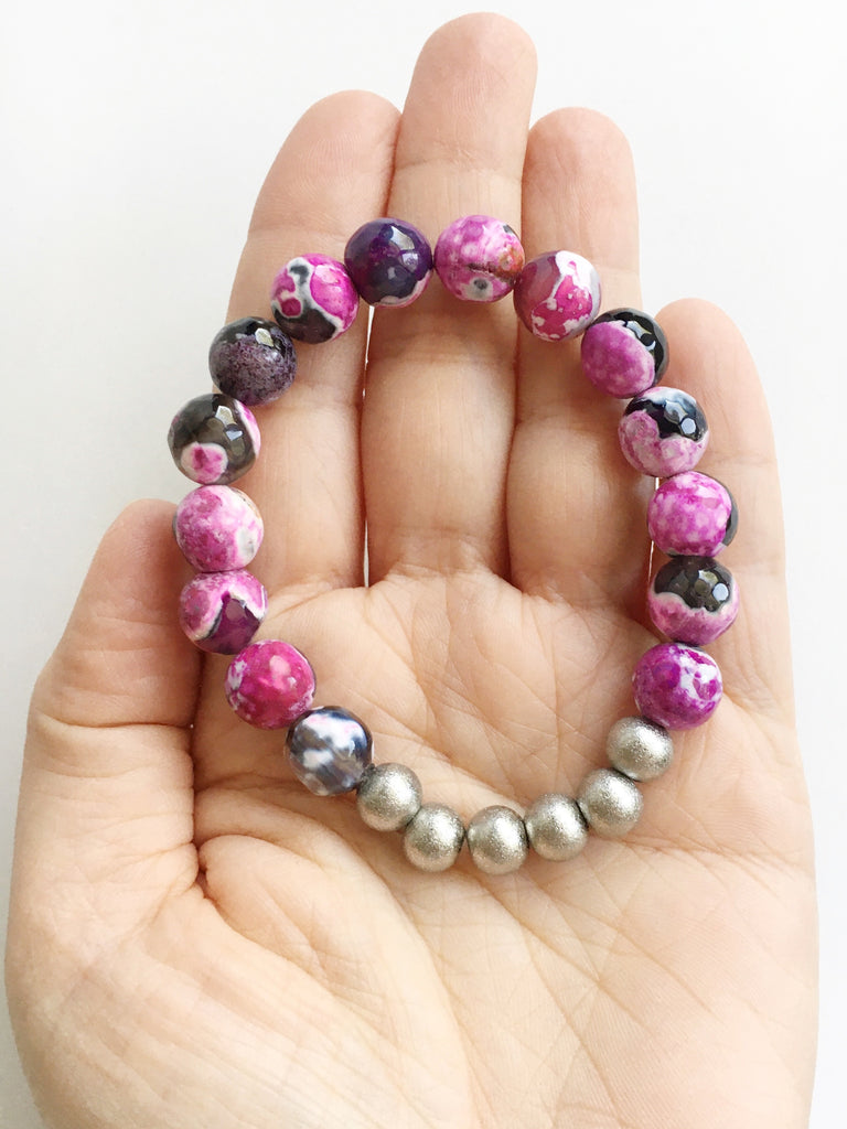 Hand holding one Pink and Black Agate and Stardust Stainless Steel Beaded stretch Bracelet