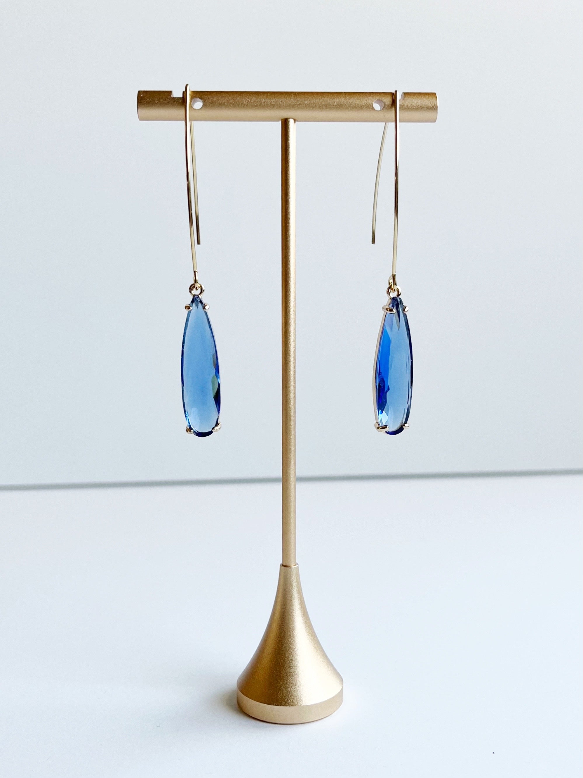 blue teardrop threader earrings on gold earring stand