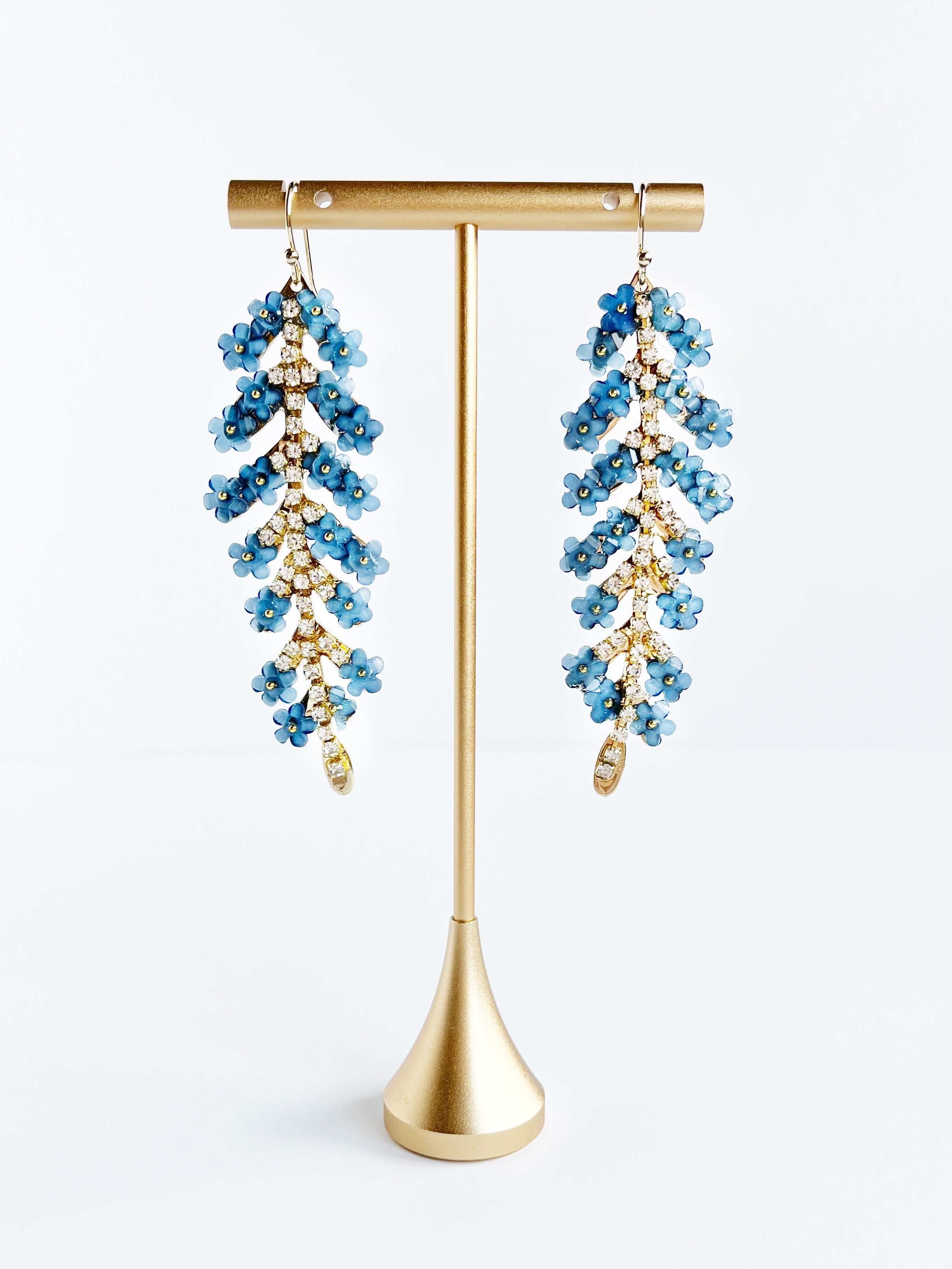 blue flower earrings on gold stand