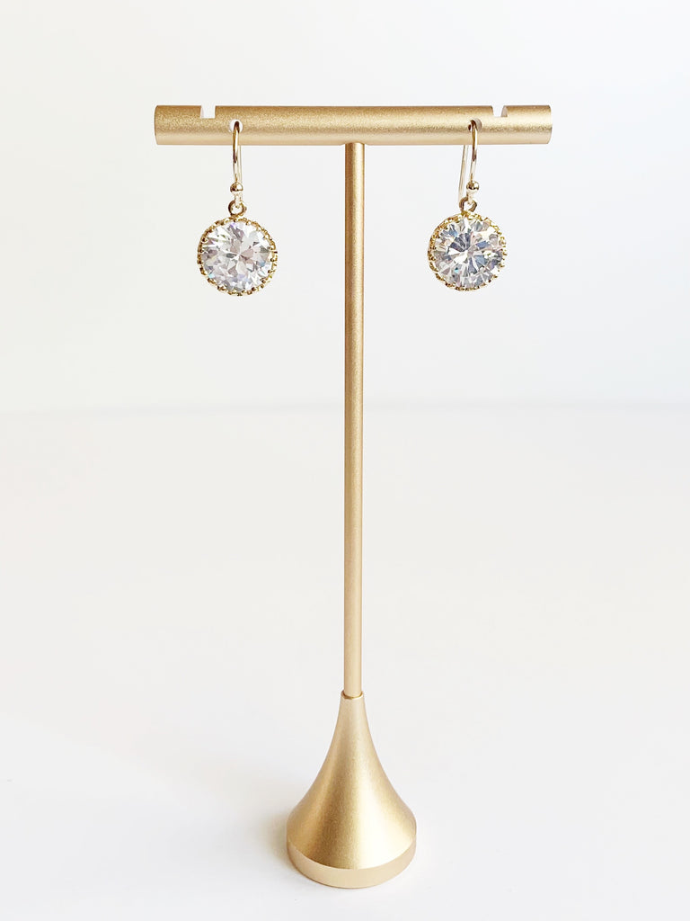 crystal dangle earrings in gold displayed on earring stand