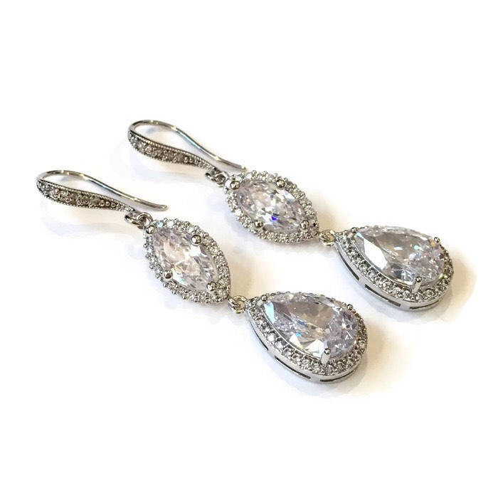 Clear cubic zirconia teardrop crystals in a silver colored rhodium plated brass setting earrings.