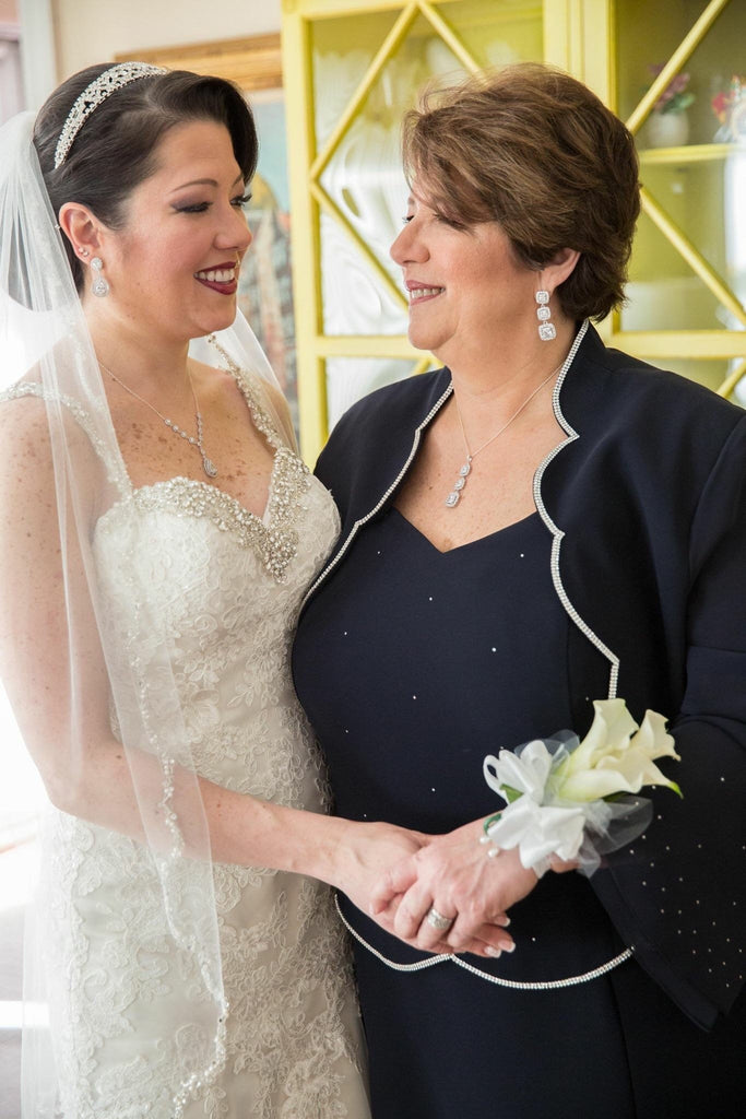 Mother of the Bride wearing Long Square Cubic zirconia crystal wedding earrings in a silver colored rhodium plated brass setting while posing with the bride