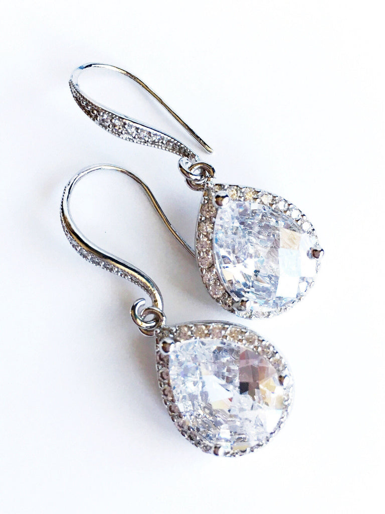 Clear cubic zirconia teardrop crystals in a silver colored rhodium plated brass setting earring.