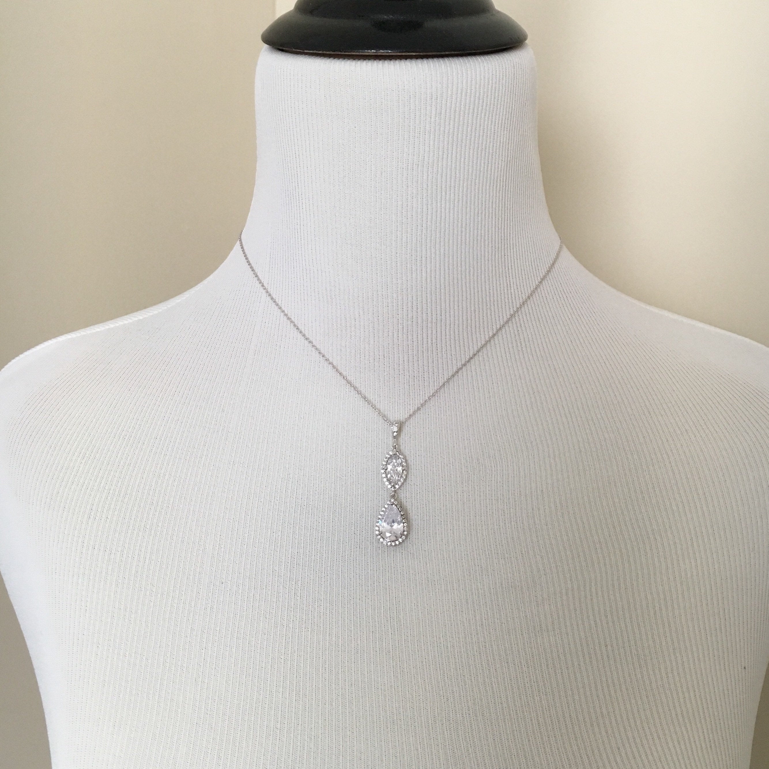 Mannequin wearing Cubic zirconia crystals set in silver color rhodium plated brass pendant necklace.