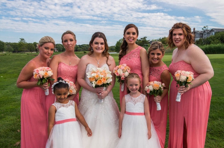 Bride and her wedding party posed, bride is wearing Round cubic zirconia Crystal Halo Dangle Earrings in a silver colored rhodium plated brass setting.