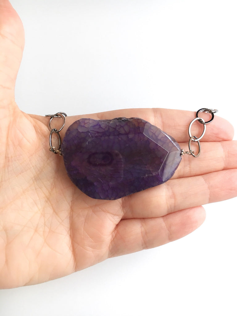 purple agate pendant necklace displayed on hand