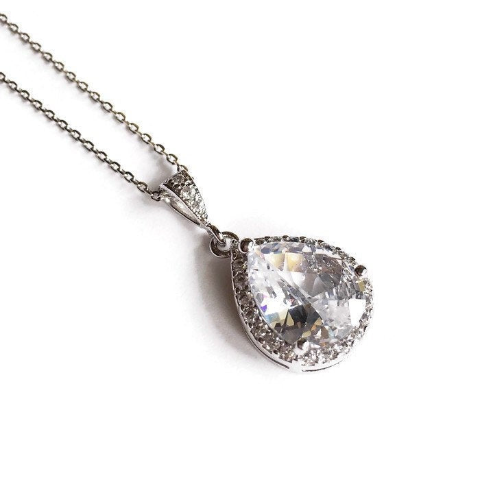 Teardrop cut cubic zirconia crystals set in silver color rhodium plated brass pendant necklace. 