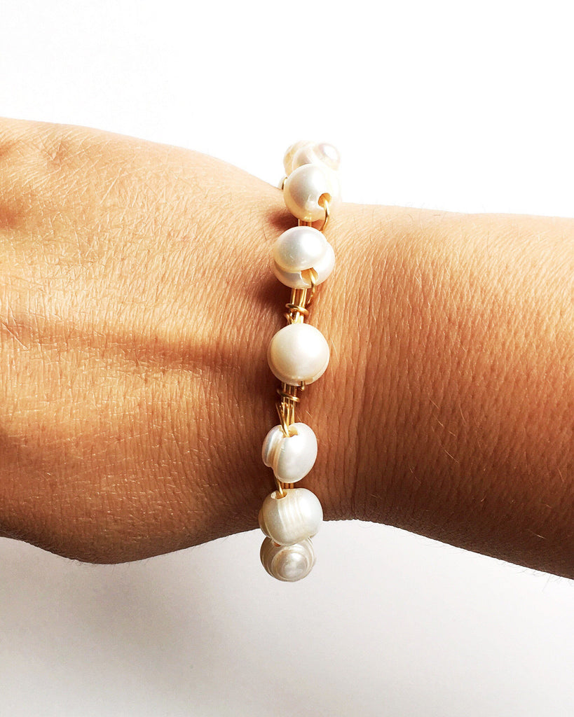Pearl and Gold Bangle Bracelet on women's wrist