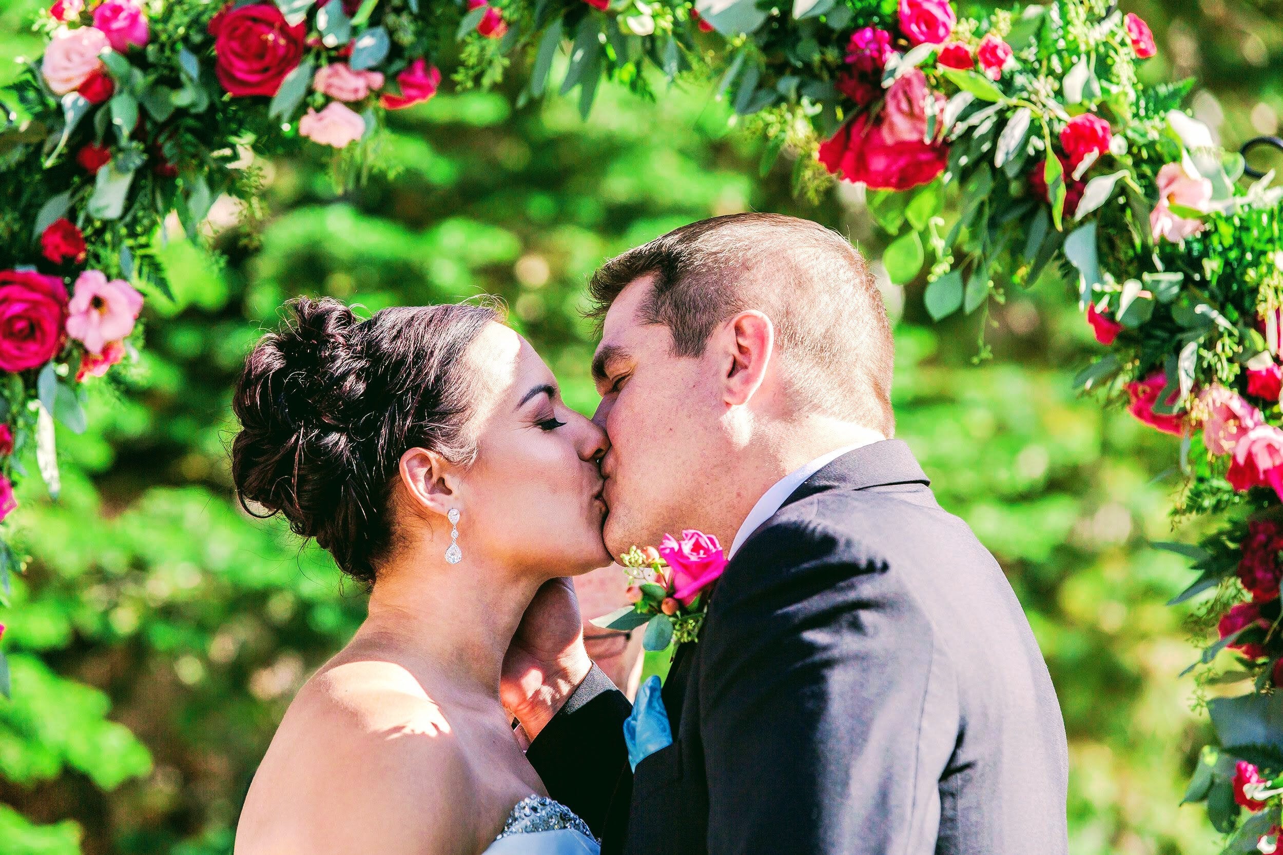 Bride wearing Long Crystal Cubic Zirconia Teardrop Earrings in a silver colored rhodium plated brass setting while kissing her new husband.