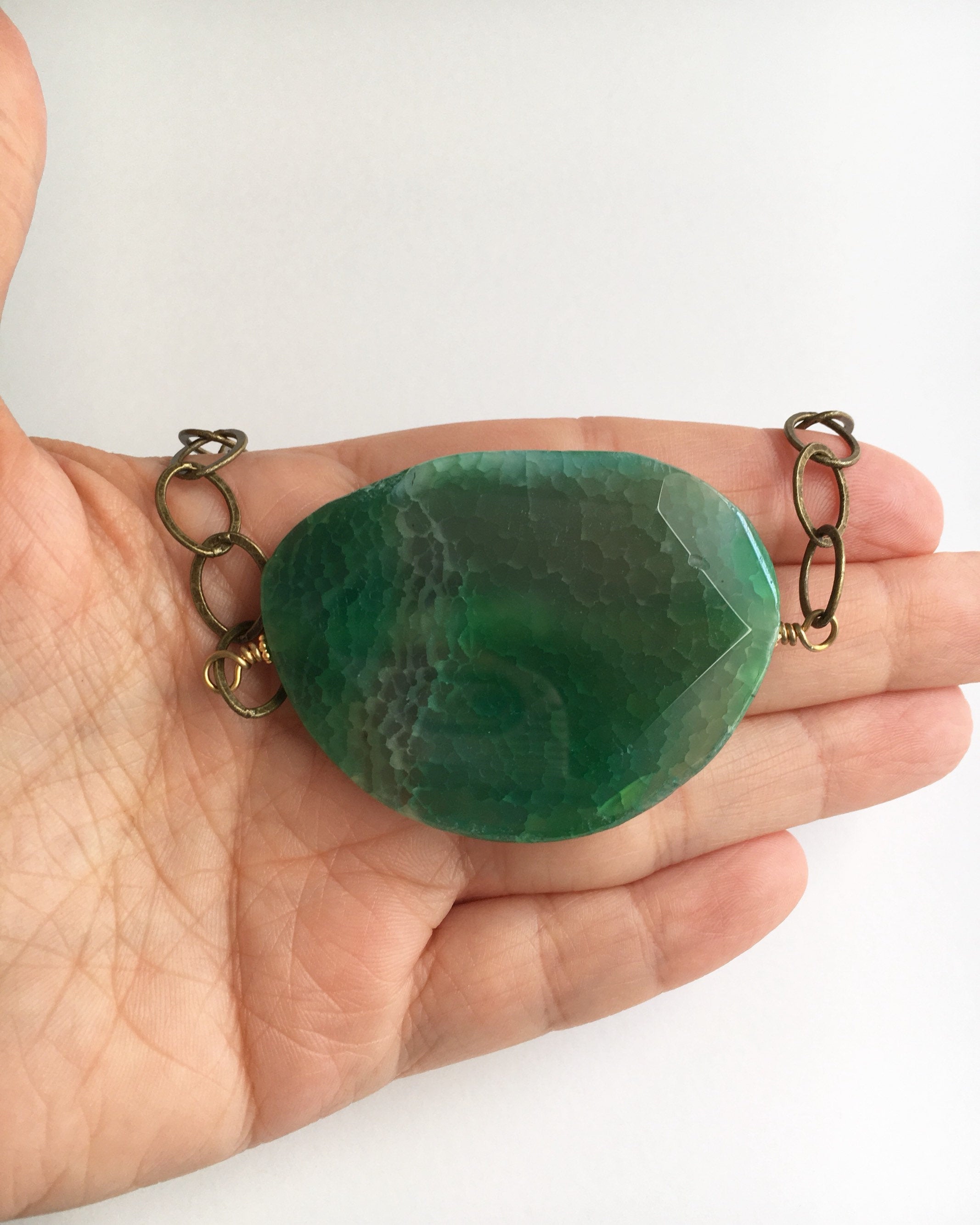 green agate statement necklace displayed on hand