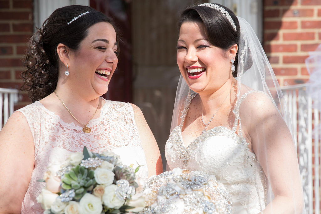 Two brides laughing while wearing Round Clear cubic zirconia Crystal Stud Earrings with halo in a silver colored rhodium plated brass setting