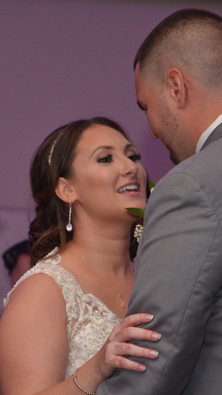 Groom looking at Bride wearing Long Clear cubic zirconia Crystal Drop Earrings in a silver colored rhodium plated brass setting.