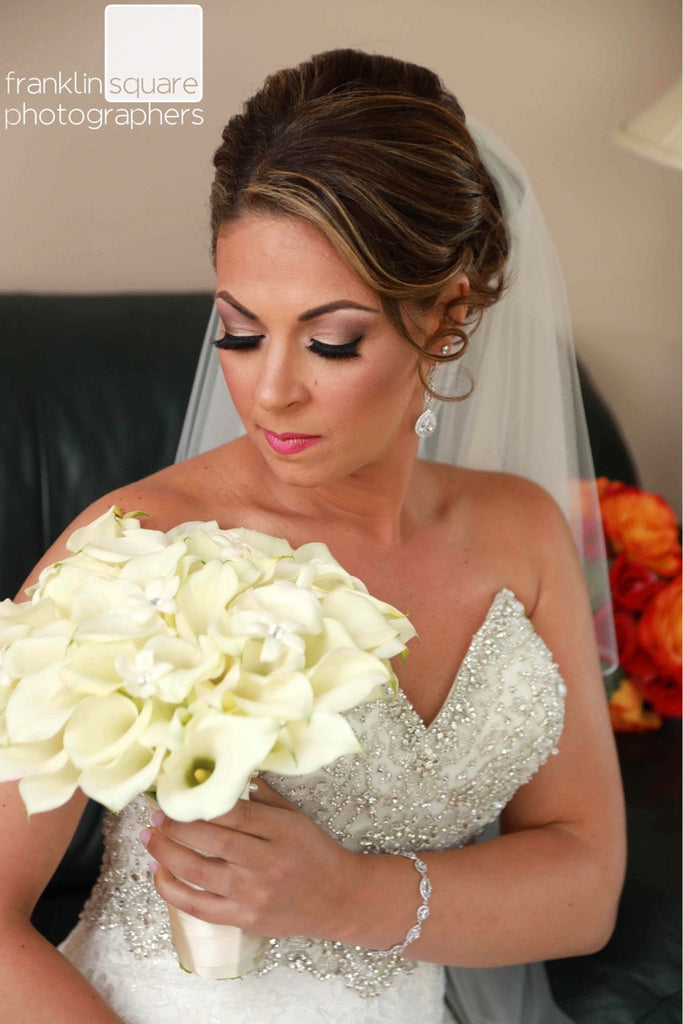 Bride looking at her bouquet wearing Marquise and Round Halo Crystal Cubic zirconia crystals set in silver color rhodium plated brass bracelet.
