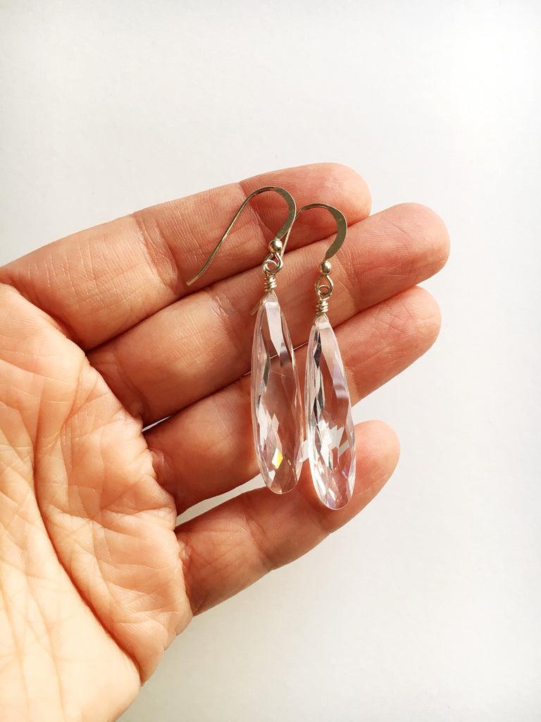 Hand holding Clear cubic zirconia teardrop crystal earrings with sterling silver hand wired loop and sterling silver ear wires