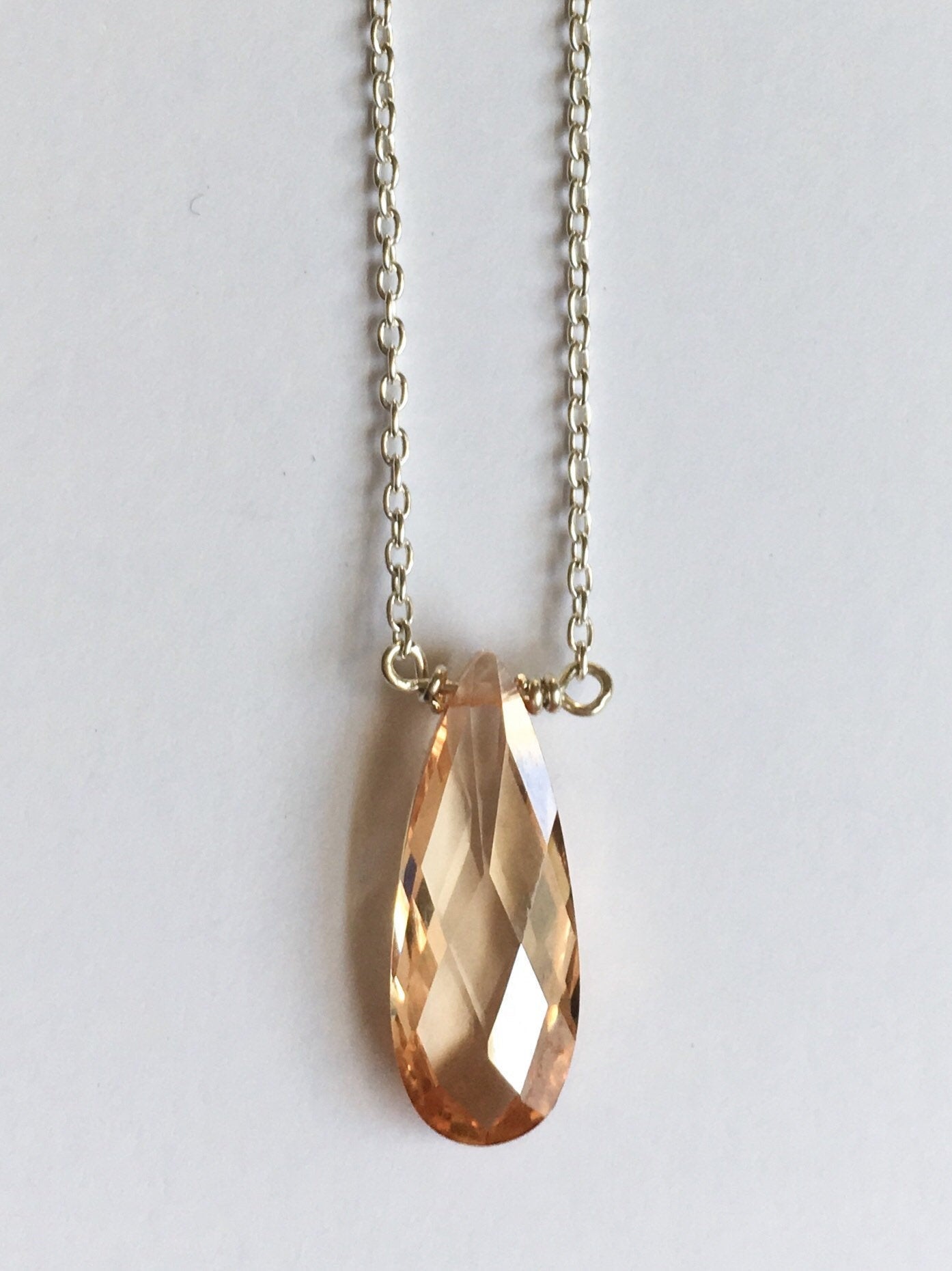 Small champaign teardrop crystal on a sterling silver chain.