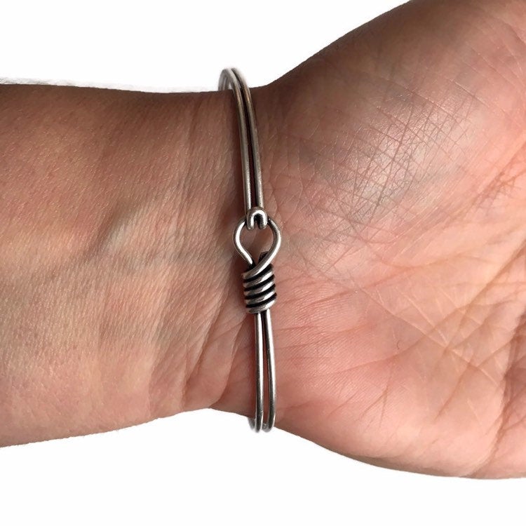 Women's wrist showing silver hook n eye clasp on statement bracelet.