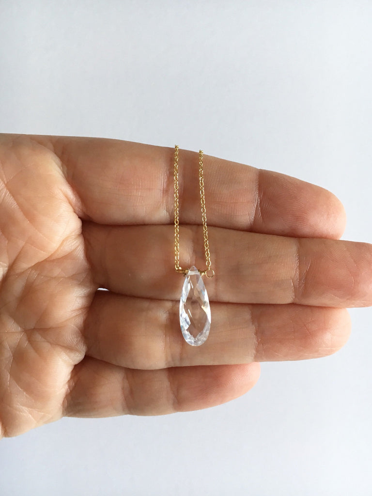 Cubic zirconia teardrop crystal pendant on gold filled chain necklace – available in clear or champaign laying over fingers.