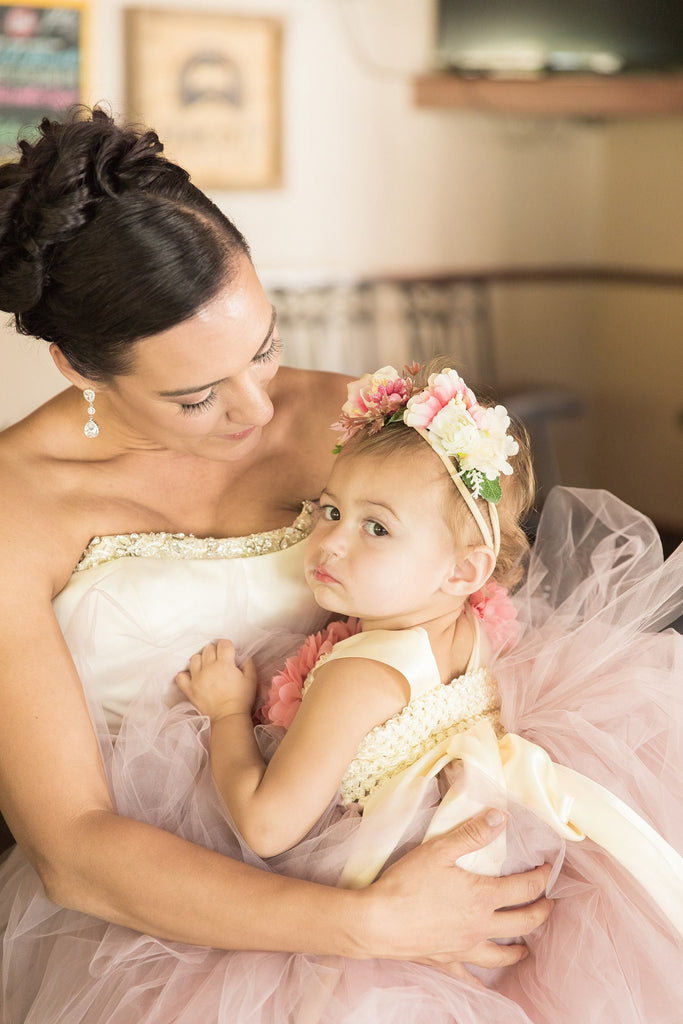 Bride holding toddler while wearing Long Crystal Cubic Zirconia Teardrop Earrings in a silver colored rhodium plated brass setting.