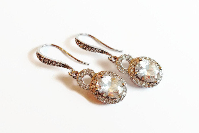 Cubic zirconia oval earrings in a silver colored rhodium plated brass setting.