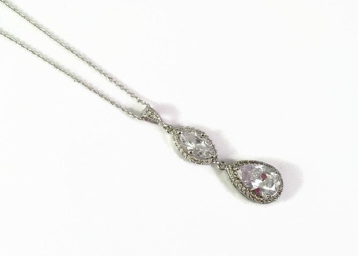 Clear cubic zirconia teardrop crystals in a silver colored rhodium plated brass setting necklace.