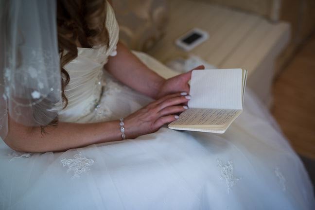 Bride reading her notebook wearing Marquise and Round Halo Crystal Cubic zirconia crystals set in silver color rhodium plated brass bracelet.