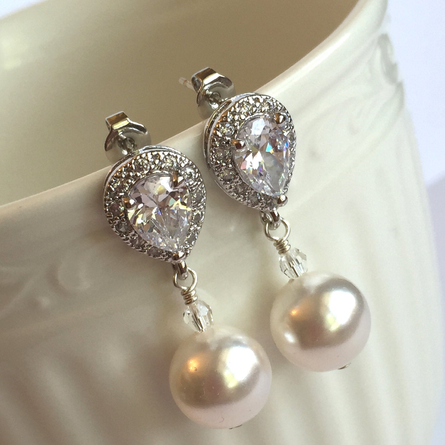 close up of White pearl drop earrings with a cubic zirconia stud