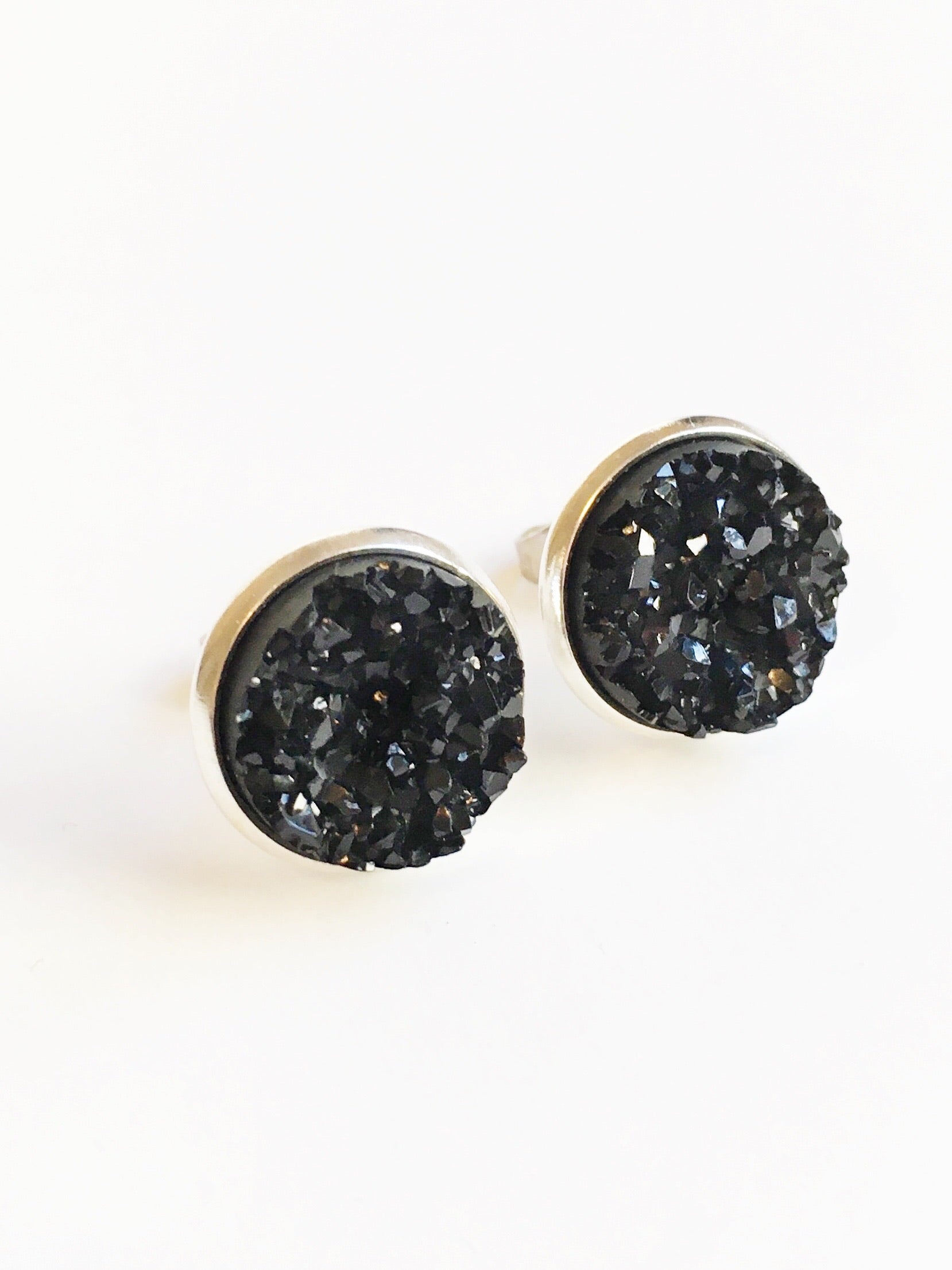 Black resin druzy stone stud earrings set in a silver color setting. 