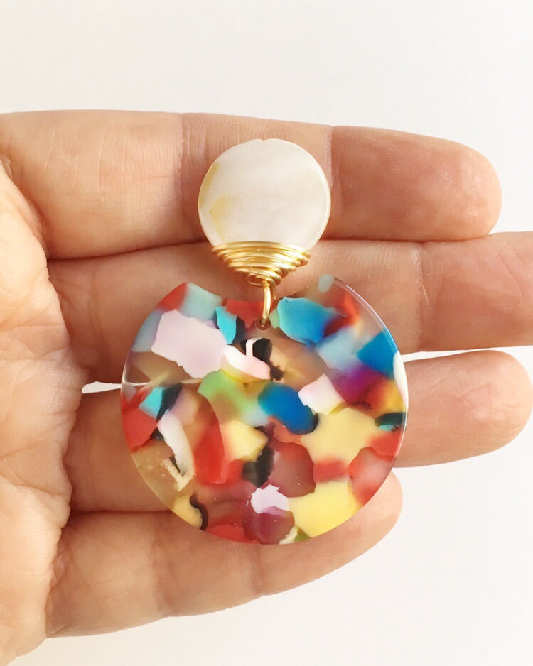 Women's hand holding Mother of Pearl, Rainbow Lucite, and Gold Wire Wrapped Earring over her fingers