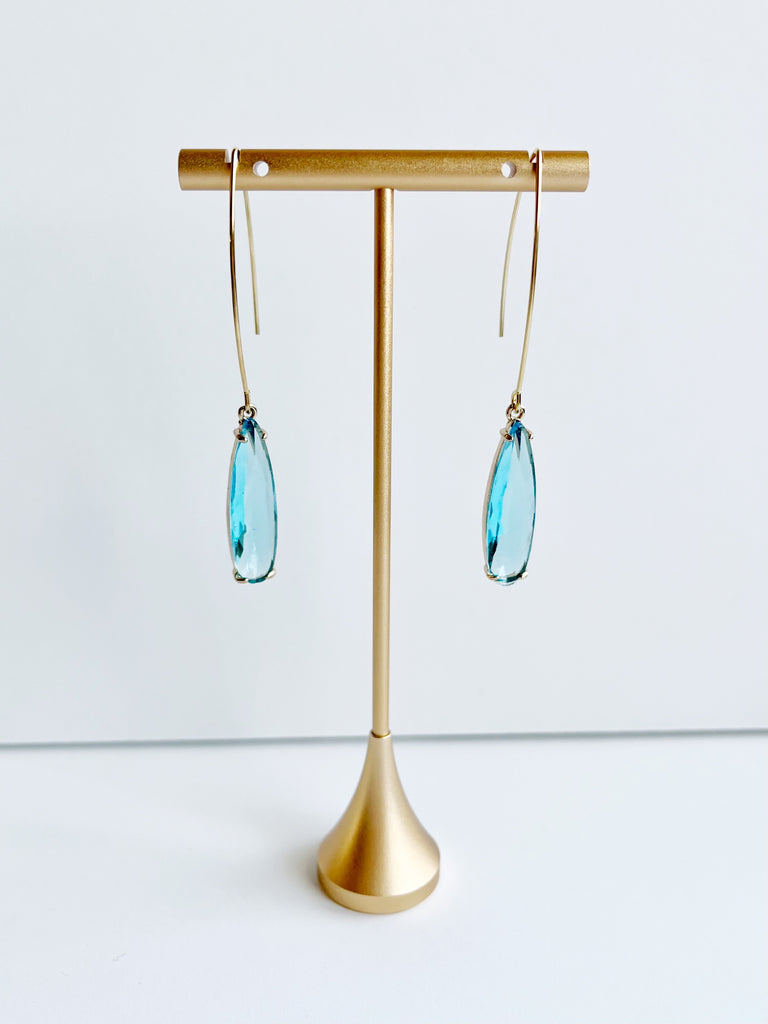 aquamarine and gold pendant earrings on gold tstand