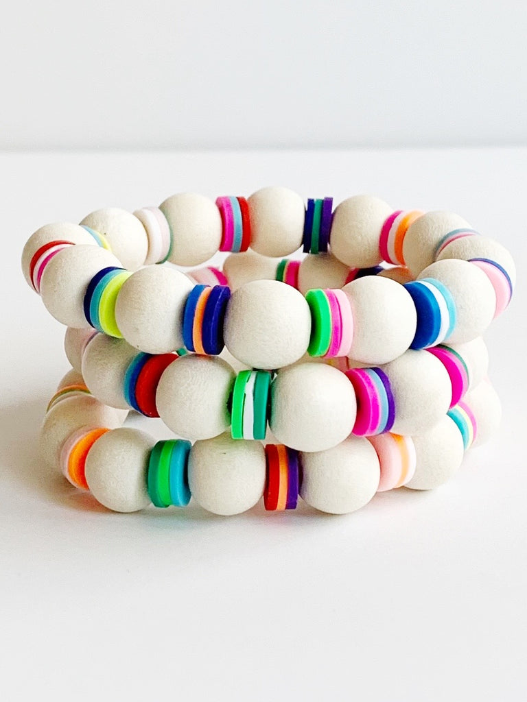 Three Child sized white wood and rainbow beads on stretch material bracelets.
