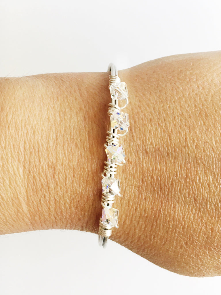 crystals and silver bangle bracelet on womens wrist