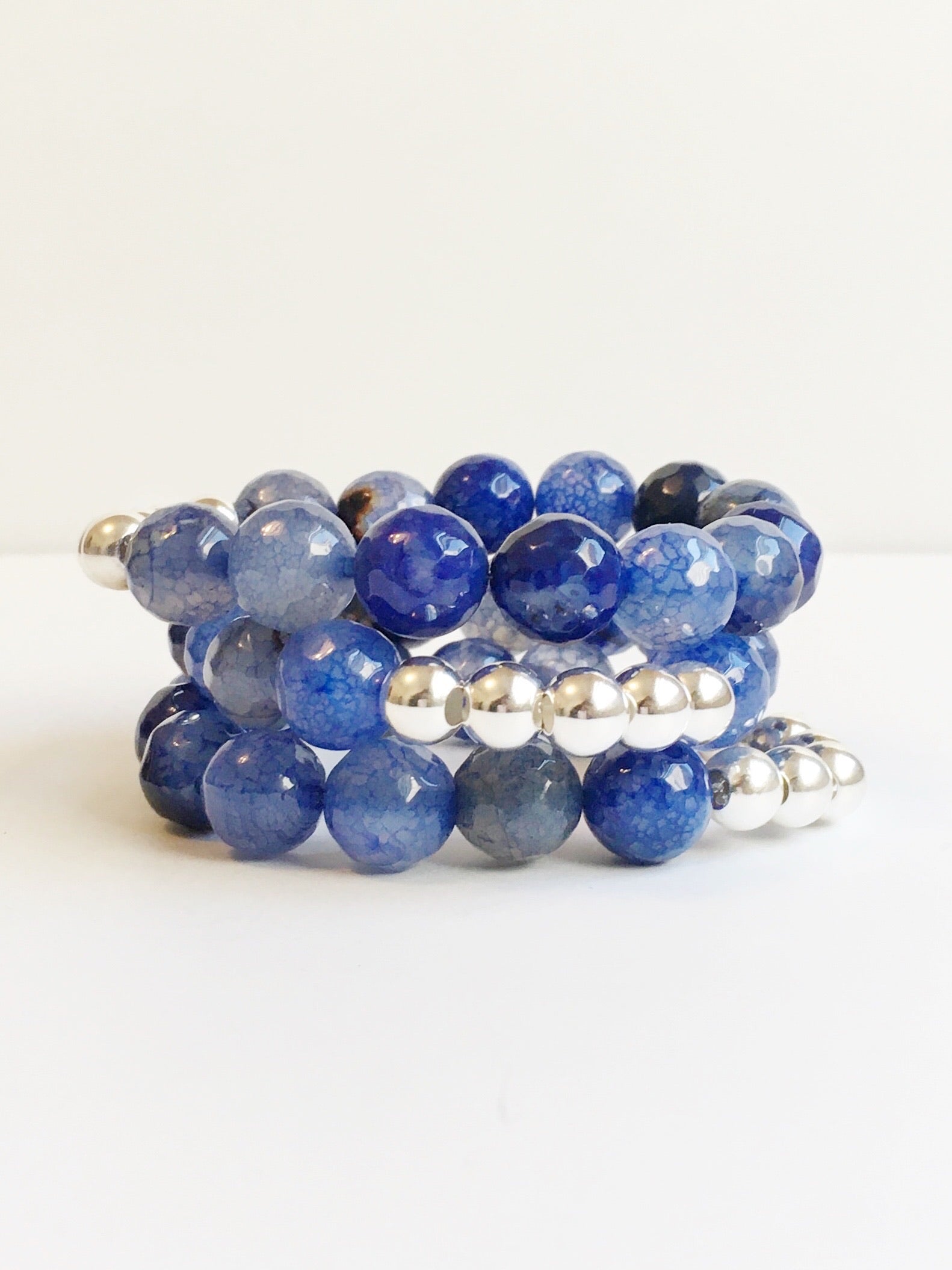 Three Blue Striped Agate and Silver Beaded Stretch Bracelets stacked.