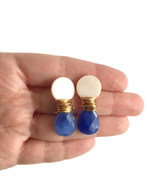 Hand holding Blue Chalcedony stone and Mother of Pearl Teardrop shell with gold plated wire Earrings.
