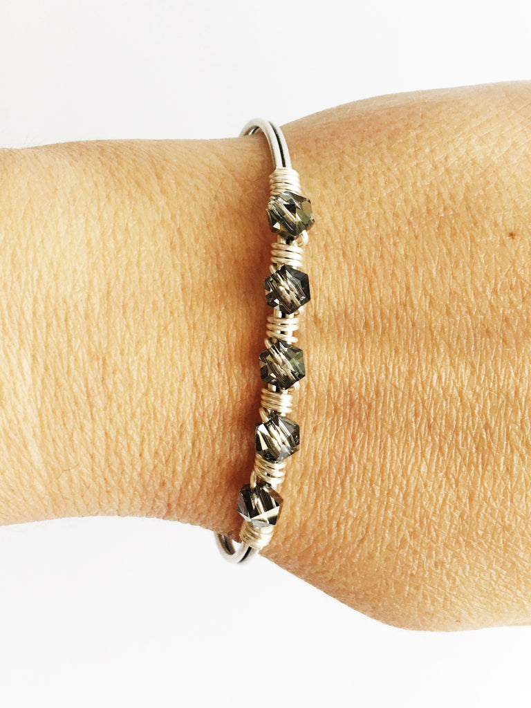 Hand wired grey crystals and silver bangle bracelet on womens wrist