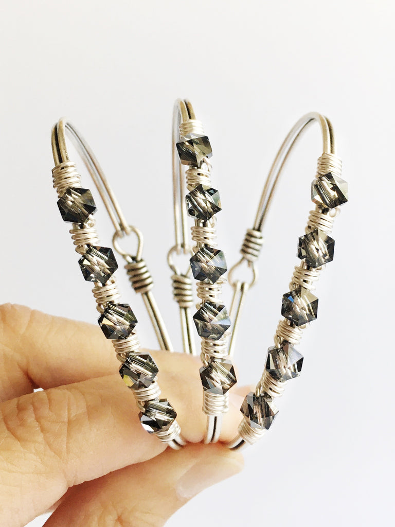 Three Hand wired grey crystals and silver bangle bracelets being held up together