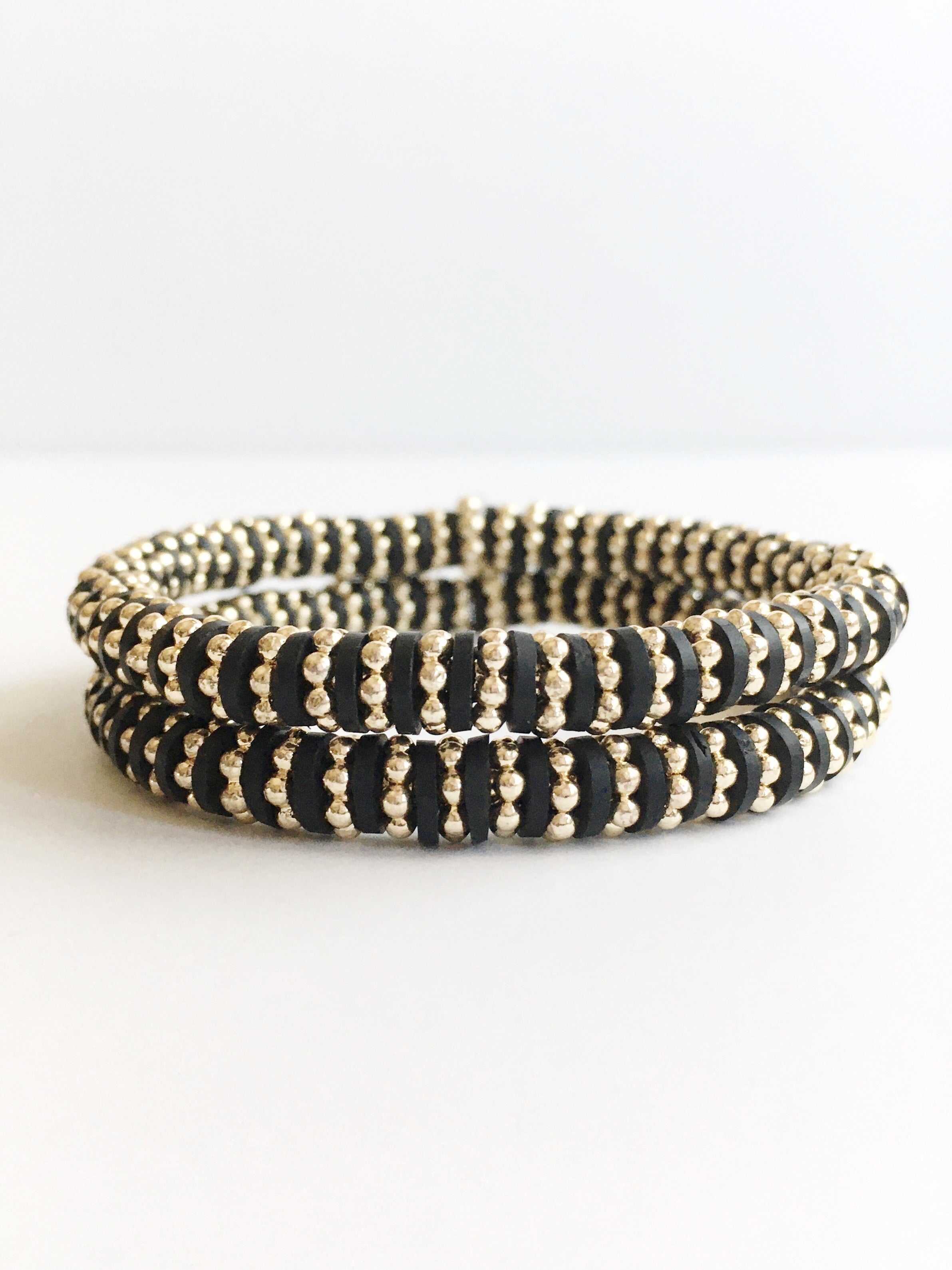 two black and gold stacking bracelets