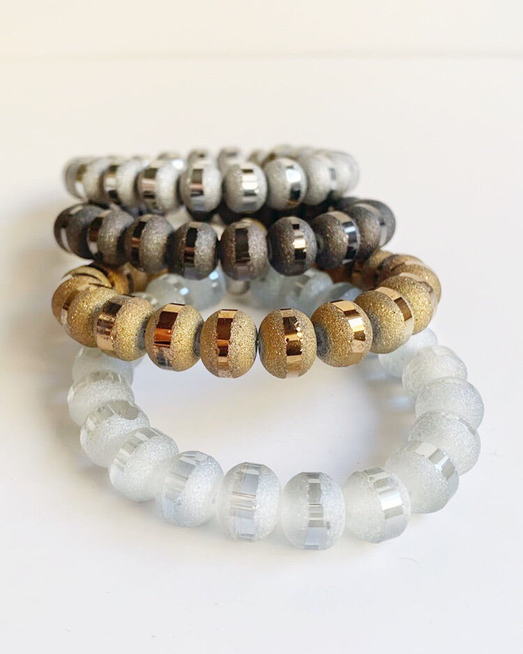 Silver, black, gold and white Hand strung orbit beads and stainless steel beads on stretch material stacked