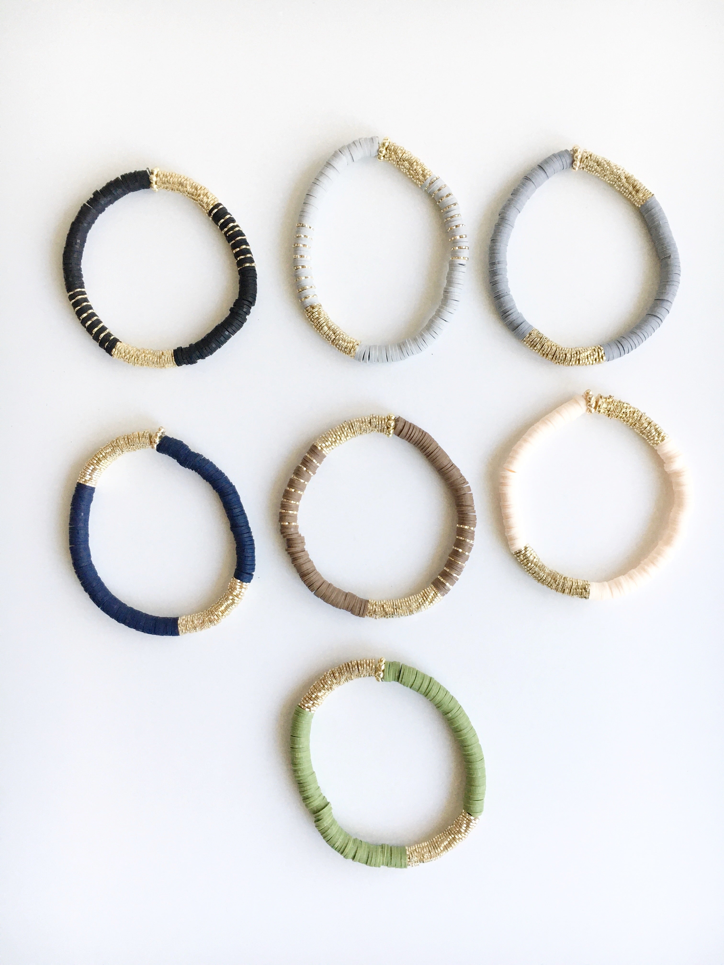 Top view of stretch beaded bracelets in Black, Light gray, dark gray, navy blue, brown, vanilla, and olive with no labels.