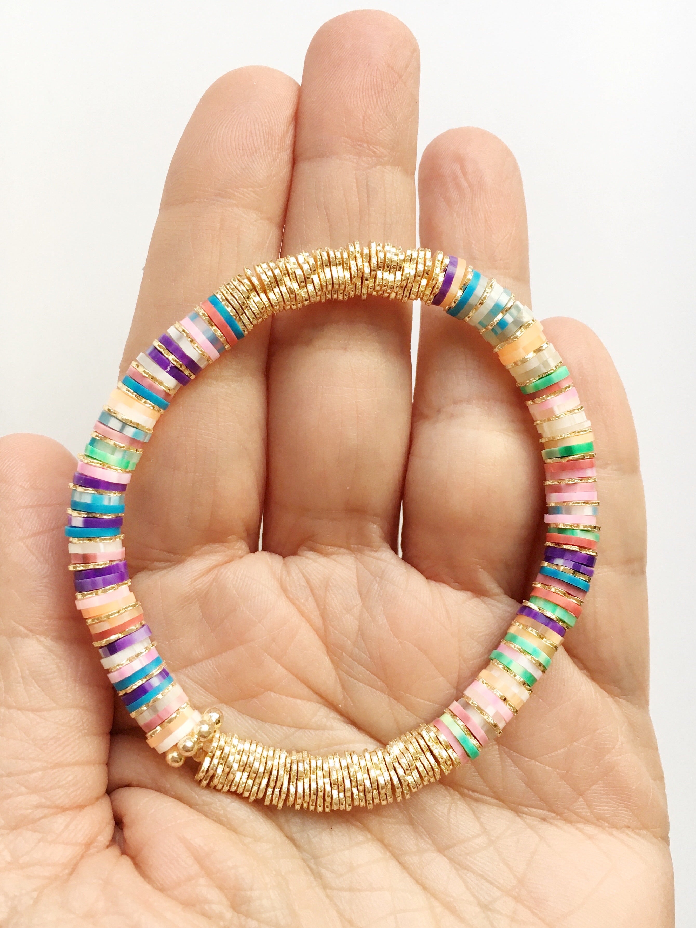 Hand holding Tie Dye Confetti and Gold Beaded Bracelet