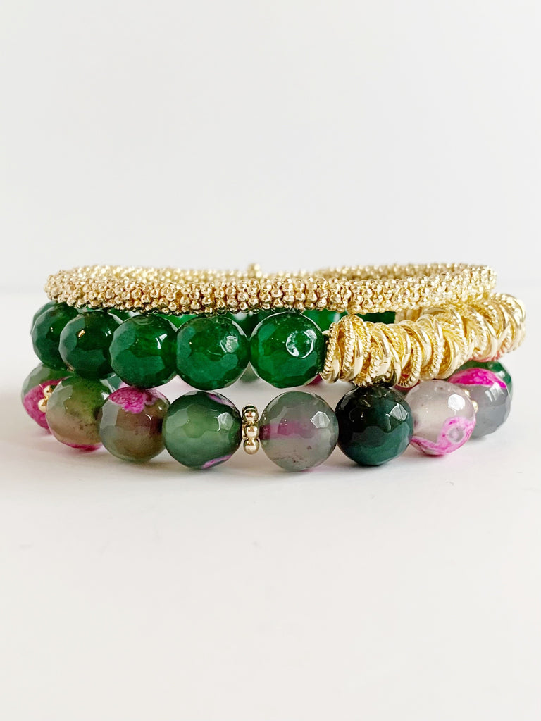 Three beaded bracelets, one of small gold confetti, one of green agate beads, and one green and pink agate beads stacked on each other.