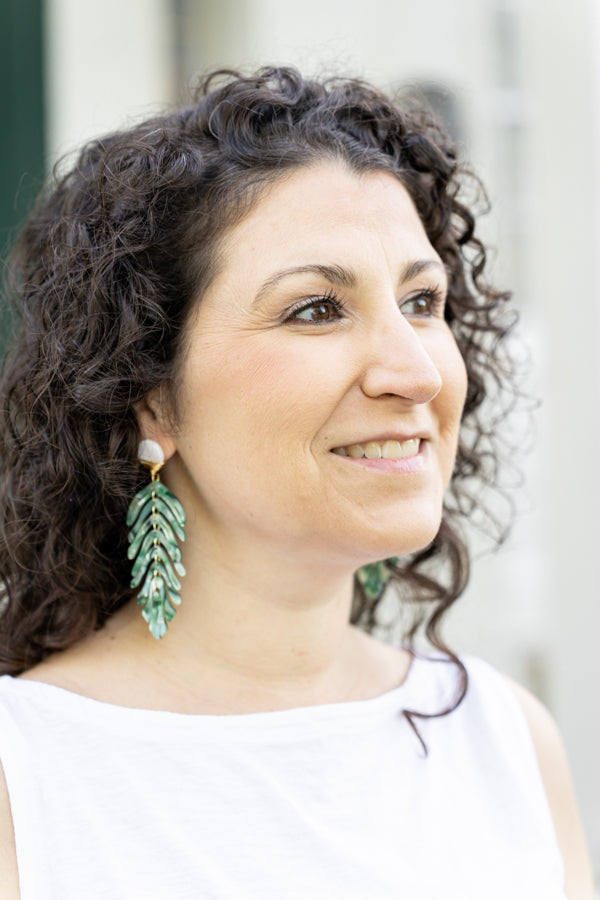 green statement earrings on woman