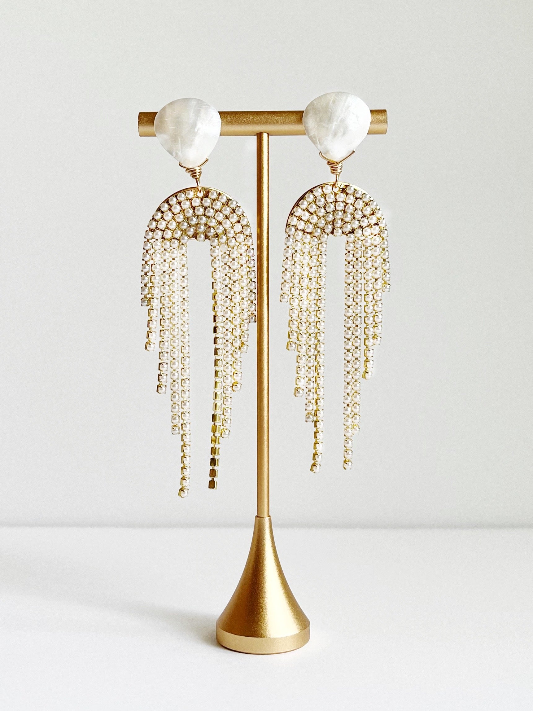 Pearl Tassel Fringe Statement Earrings displayed on gold earring tstand