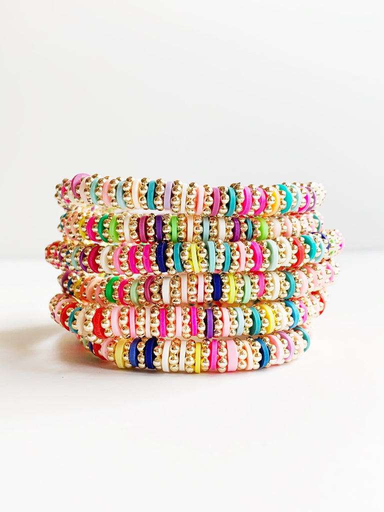 Six  Gold and Rainbow Confetti Stretch Bracelets stacked.