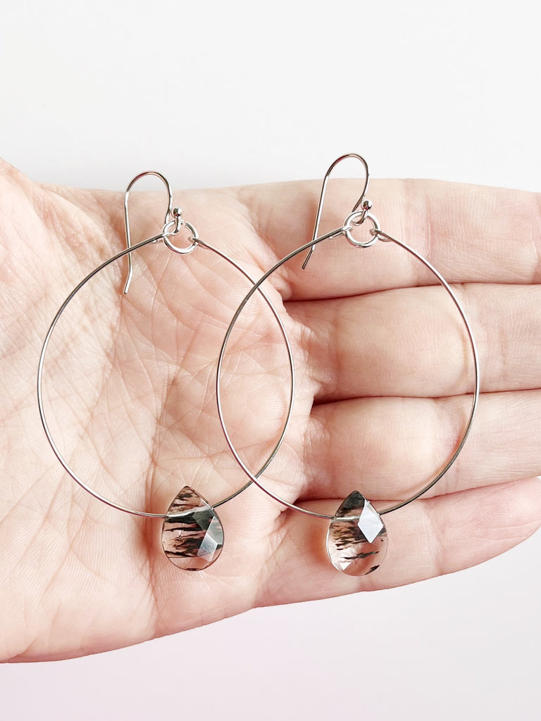 Silver Hoop Earrings with Gemstone Drop displayed on hand