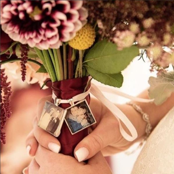 Two Vintage silver color pewter bridal bouquet charm tied to bouquet with ribbon.